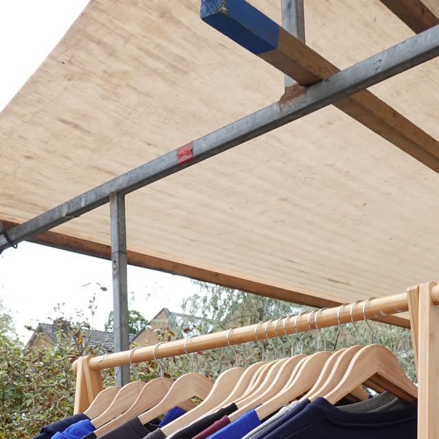 Een rek met HIZ-kleding bij de kraam.