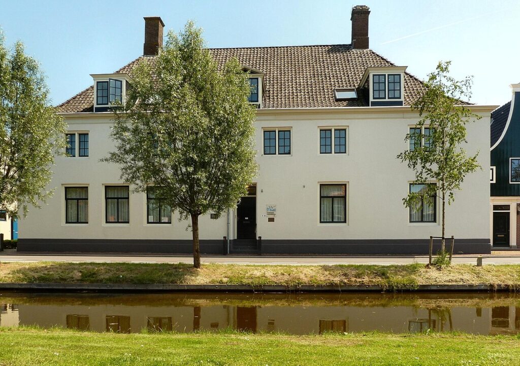 Wit huis aan het water van de Vlusch in Krommenie